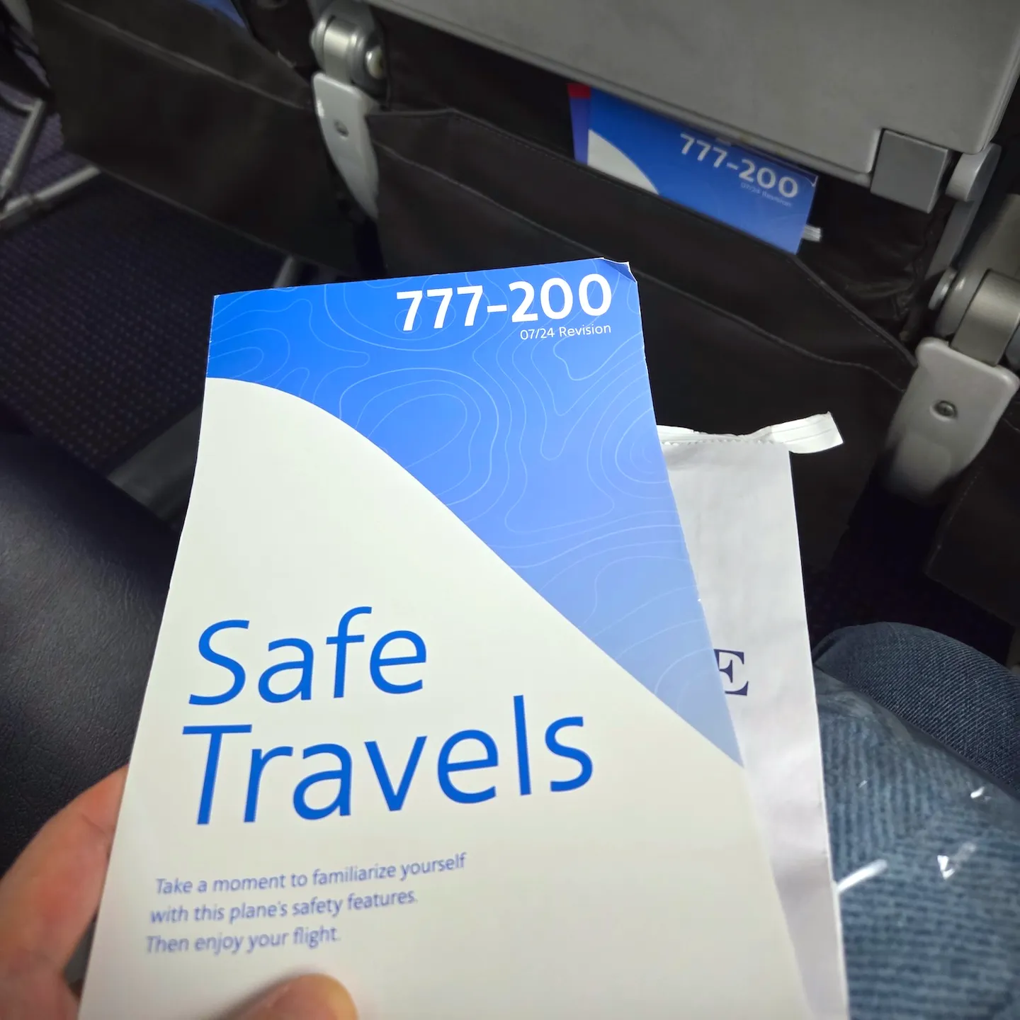 Safety Card, Main Cabin Extra Overhead Bin, and Overhead Reading Lights on American Airlines B777-200ER